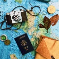 An old camera and a passport are placed on a world map