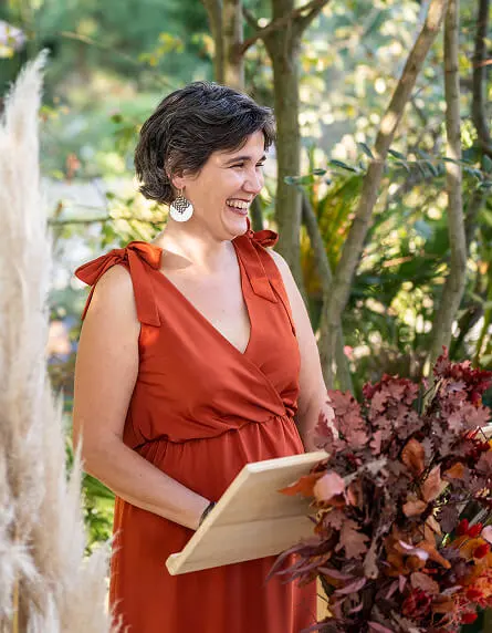 Delphine, the ceremony officiant, smiles before starting her speech for the wedding. Photo credit: The Luuxx