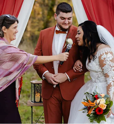 Delphine Goudy, the ceremony officiant, hands the microphone to the newlyweds for their vows. Photo credit: Creat2vision