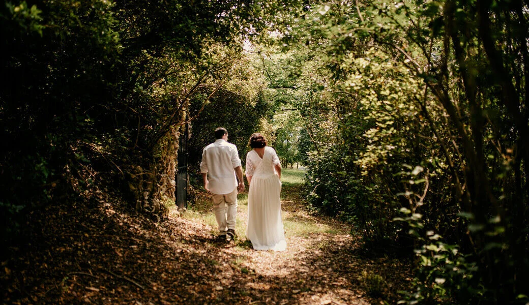 Des mariés s’éloignent dans la forêt pendant leur fugue amoureuse dans le Tarn. Crédit photo : Sophie Bachère