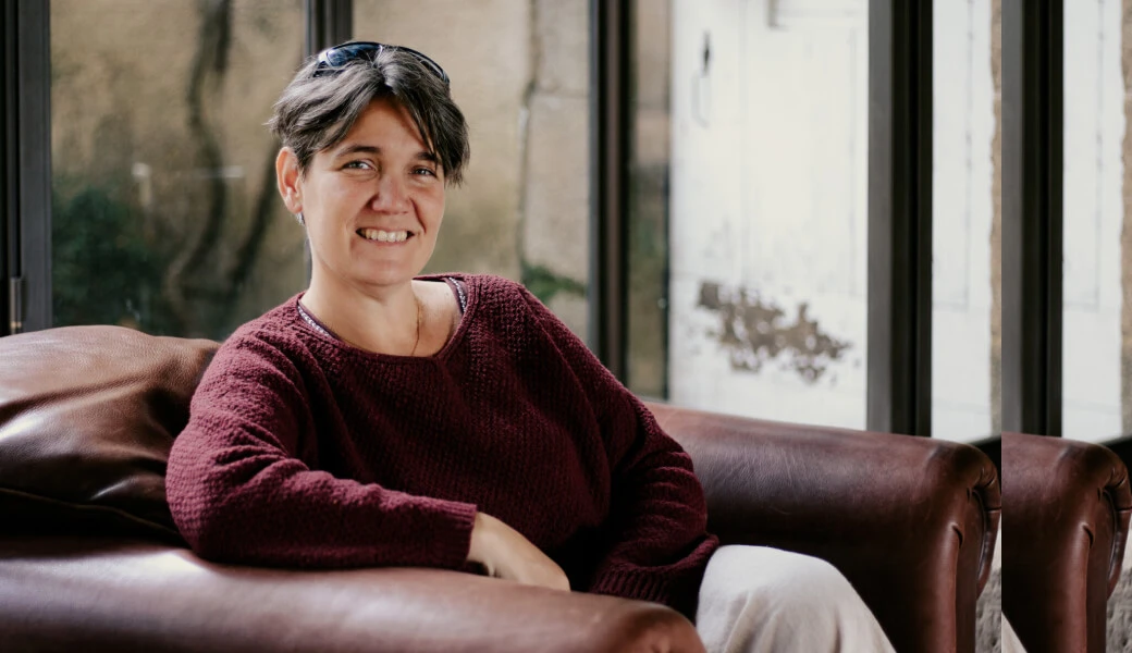 Delphine Goudy, wedding planner à Toulouse, sourit assise dans son canapé.