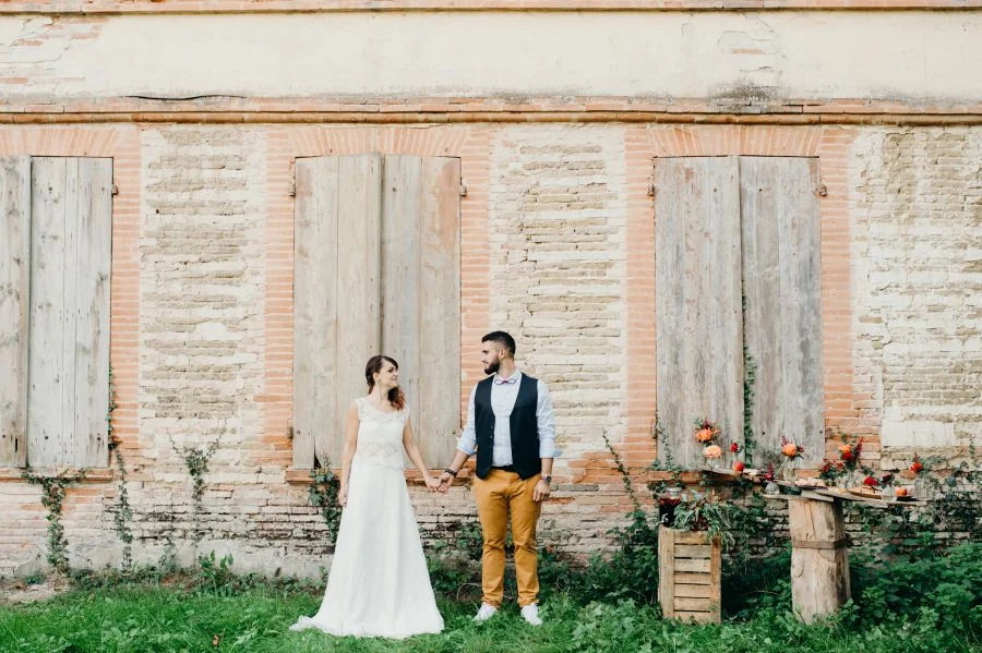 Couple qui se tient la main devant une maison
